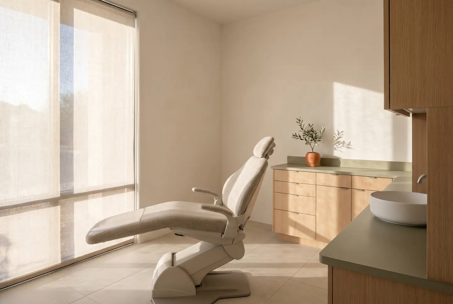 A treatment room in pale oak and stone linen, lit by low afternoon sun